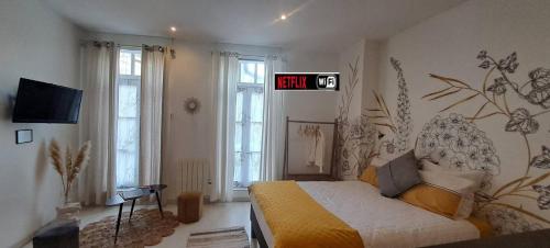 Un dormitorio con una cama y un reloj en la pared. en Les arcades Studio Coeur de ville, en Cholet