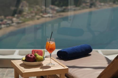 a table with a bowl of fruit and a drink at Zeus Throne Suites in Afionas