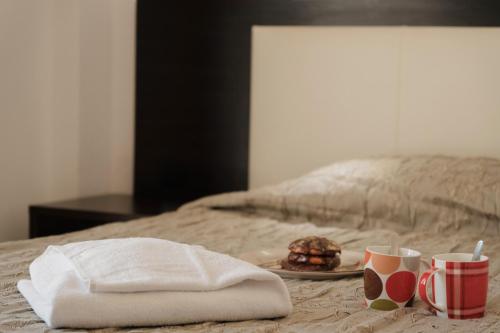 a plate of food on a bed with two cups at Zeus Throne Suites in Afionas