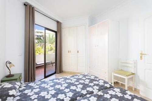 a bedroom with a bed and a sliding glass door at Apartamento con vistas al jardín in Puerto de la Cruz