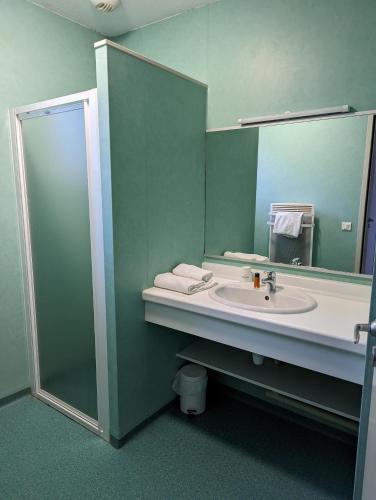 une salle de bain avec un lavabo et un miroir dans l'établissement Le Herbau, à Gérardmer