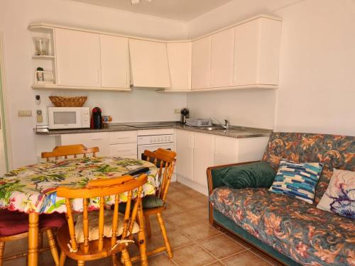 Una cocina y una sala de estar con una mesa y un sofá. en As055 Noa - Cosy 2 bedroom in the green oasis, en San Juan de los Terreros