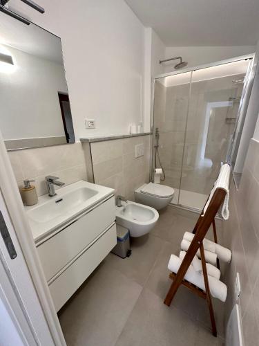 a white bathroom with a sink and a toilet at Casa Camilla in Riomaggiore