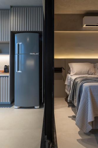 a refrigerator in a room next to a bed at Loft Marília City in Marília