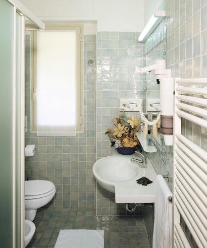 a bathroom with a white sink and a toilet at Hotel Angela in Fano