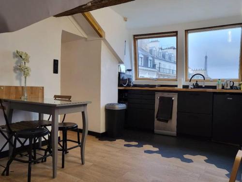 une cuisine avec une table et des chaises dans une pièce dans l'établissement View Eiffel Tower, à Paris