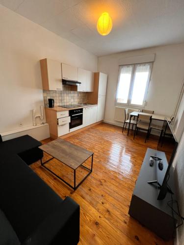 un salon avec un canapé et une table dans l'établissement Appt 2 pcs st Quentin Centre, à Saint-Quentin