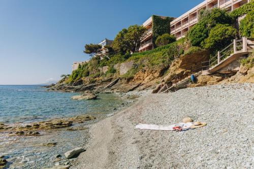 a person laying on a beach next to the ocean at Alivi in Bastia