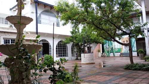 un cortile di un edificio con un albero di Continental Hotel a Curuzú Cuatiá