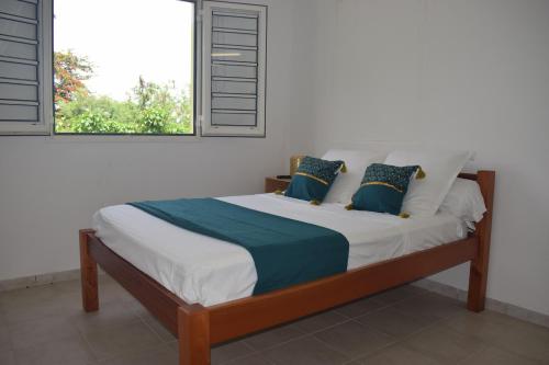 a bed in a room with a window at CHAUDIERE DE RÊVE in Le Vauclin