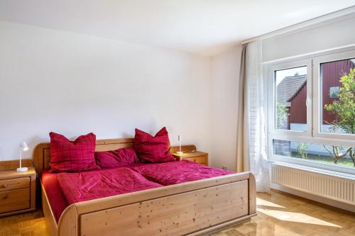 a bedroom with a large bed with red pillows at Grashüpfer Plus bis 6 Pers in Freiensteinau