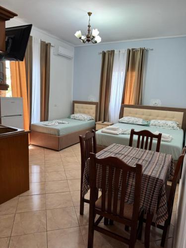 a living room with two beds and a table and chairs at Garden Villa Veli in Ksamil