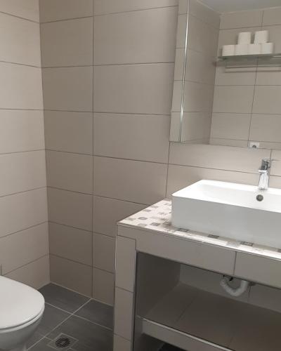 a white bathroom with a sink and a toilet at Super renovated maisonette - Σούπερ ανακαινισμένη μεζονέτα in Filiatra