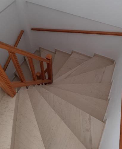 a wooden staircase with a wooden rail and a stair case at Super renovated maisonette - Σούπερ ανακαινισμένη μεζονέτα in Filiatra
