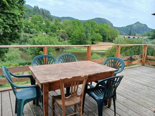 une table et des chaises en bois sur une terrasse avec vue dans l'établissement Maison Soleils, à Chamalières-sur-Loire