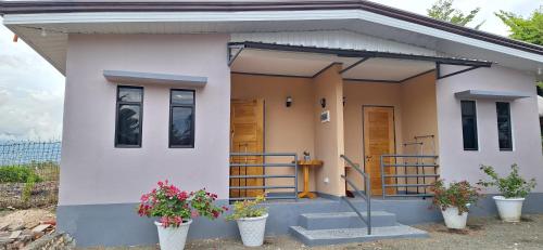 a small house with two potted plants in front of it at Villa Kendra in Moalboal
