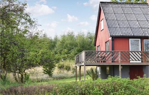 a red house with a balcony on the side of it at Two-Bedroom Holiday Home In Orkelljunga in Orkelljunga
