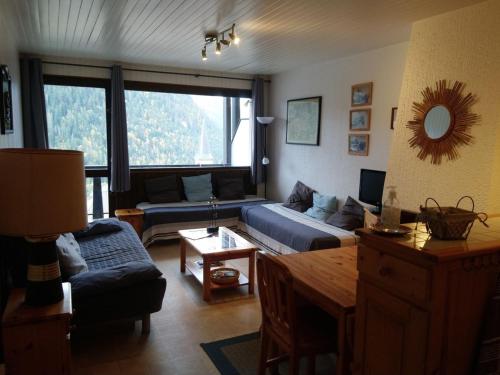 un salon avec un canapé et une table dans l'établissement Studio cosy avec balcon, 20m des remontées mécaniques, plein centre Châtel, idéal 3 pers. - FR-1-676-113, à Châtel