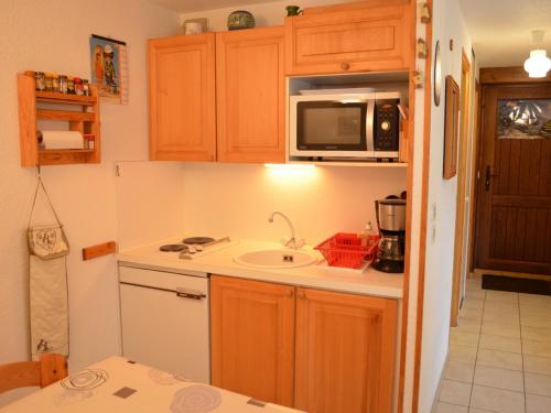 une petite cuisine avec un évier et un micro-ondes dans l'établissement Appartement cosy 5 pers. à Châtel, terrasse sud, proche télésièges et services - FR-1-676-139, à Châtel