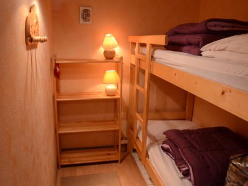 Cette petite chambre comprend 2 lits superposés et une lampe. dans l'établissement Appartement cosy 5 pers. à Châtel, terrasse sud, proche télésièges et services - FR-1-676-139, à Châtel