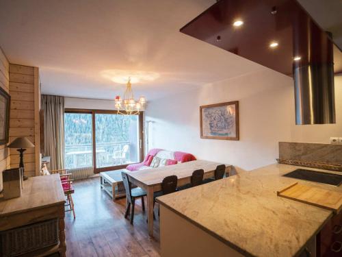 une cuisine et un salon avec une table et un canapé dans l'établissement Appartement cosy avec balcon, Châtel - 6 pers., proche télésiège et centre, garage inclus - FR-1-676-172, à Châtel