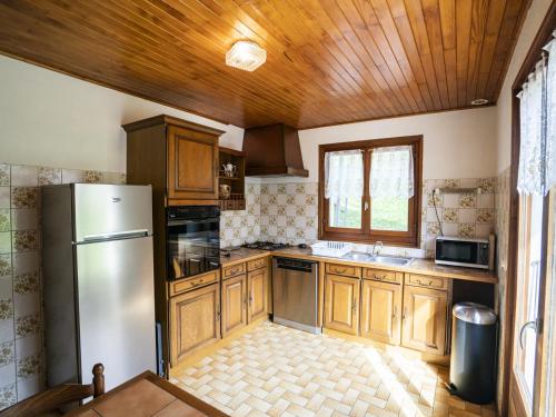 une cuisine avec des armoires en bois et un réfrigérateur en acier inoxydable dans l'établissement Appartement Châtel 95m², 3 Chambres, 2 Salles de bains, 8 Pers., Balcon/Terrasse, Parking, WIFI - FR-1-676-177, à Châtel