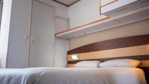 a bedroom with a large bed with a wooden headboard at FastHotel Montpellier Ouest - Un Hôtel FH Classic in Saint-Jean-de-Védas