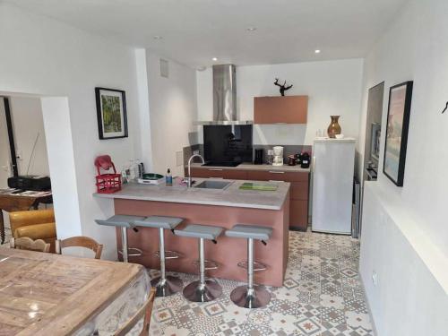 une cuisine avec évier et comptoir avec tabourets de bar dans l'établissement Gite Chez Henry, à Les Epsailles