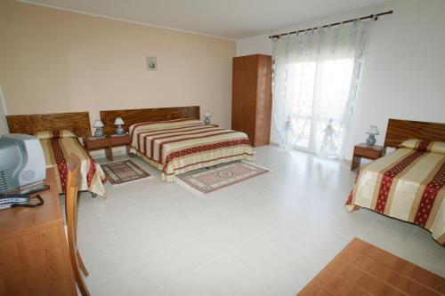 a bedroom with two beds and a tv in it at B&B La Ganzaria in San Michele di Ganzaria