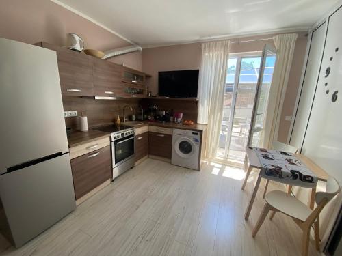 cocina con nevera blanca y mesa con mesa en Byala Leisure Place, en Byala