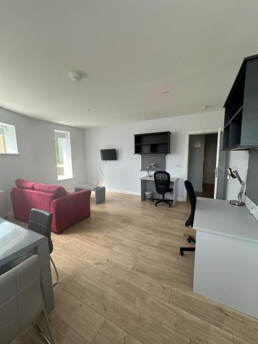 a living room with a red couch and a table at SWUITE GALWAY in Galway