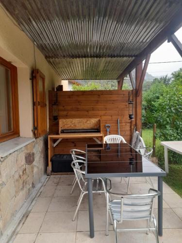 un patio avec une table et des chaises sous un toit dans l'établissement Appartement avec jardin au pied de l'alpe d'huez, à La Garde