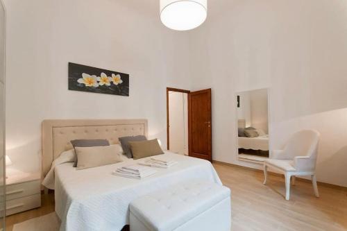 a bedroom with a bed and a chair and a mirror at Pendici di Fiesole - Appartamento Tuff Stone in Florence