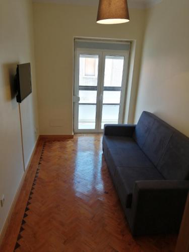 a living room with a couch and a large window at Oriente DNA Studios V in Lisbon