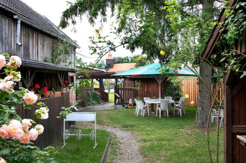 a patio with tables and chairs in a yard at Haus Meistereck Melzow in Melzow