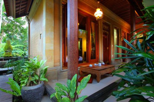 a porch of a house with a wooden table at De Umah Bali Eco Tradi Home in Bangli