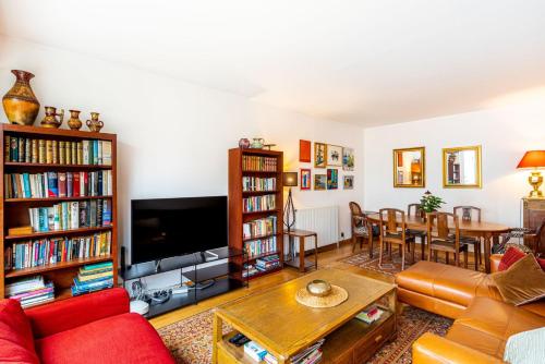 un salon avec un canapé rouge et une télévision dans l'établissement GuestReady - Séjour au calme à Belleville, à Paris