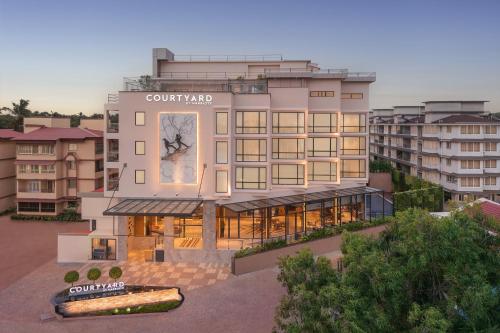a building with a clock on the side of it at Courtyard by Marriott Goa Colva in Colva