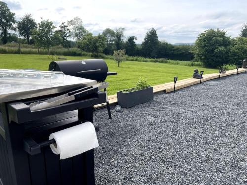 a grill sitting on top of a gravel yard at Spacious Luxury countryside retreat in Estry