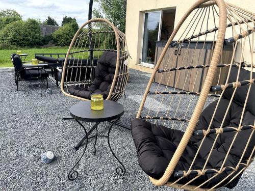 two swing chairs and a table with a glass of wine at Spacious Luxury countryside retreat in Estry