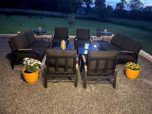 a group of patio chairs and a table with flowers at Spacious Luxury countryside retreat in Estry