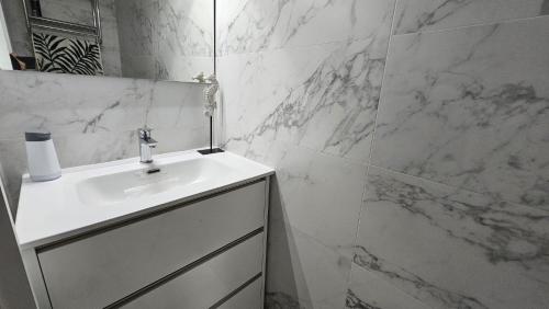 un bagno bianco con lavandino e specchio di Bungalow Morro de Gos II REF 054 a Oropesa del Mar
