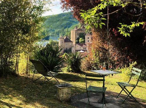 - une table et des chaises dans la cour d'une maison dans l'établissement Des Châteaux entre les Feuilles - Parc vue Village, à Puy-lʼÉvêque