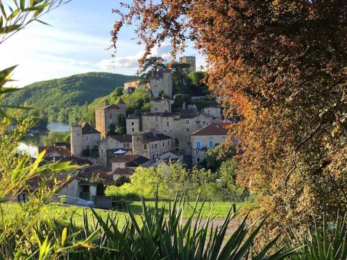 une ville au sommet d'une colline avec un château dans l'établissement Des Châteaux entre les Feuilles - Parc vue Village, à Puy-lʼÉvêque