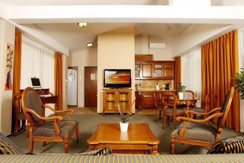 a living room with a couch and chairs and a tv at Jaukūs Friedricho pasažo apartamentai in Klaipėda