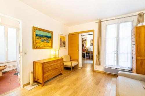 Il comprend un salon doté de murs blancs et de parquet. dans l'établissement GuestReady - Sweet Escape near the Panthéon, à Paris