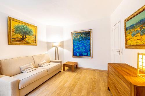 un salon avec un canapé et des tableaux au mur dans l'établissement GuestReady - Sweet Escape near the Panthéon, à Paris