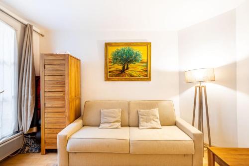 un salon avec un canapé et un tableau au mur dans l'établissement GuestReady - Sweet Escape near the Panthéon, à Paris