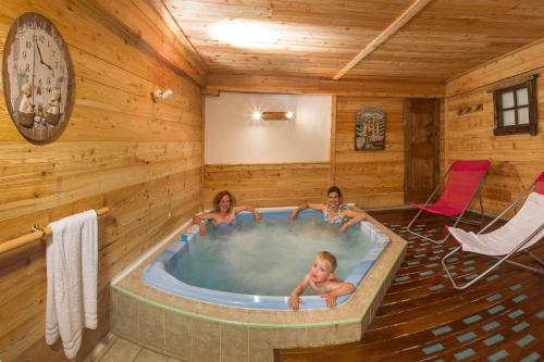 three children in a hot tub in a log cabin at Le Chalet d'en Hô in Névache