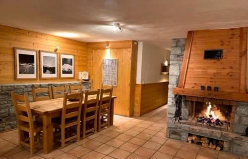 une salle à manger avec une cheminée, une table et des chaises dans l'établissement Montagnard - 4 bedroom apartment with stunning views, à Sainte-Foy-Tarentaise